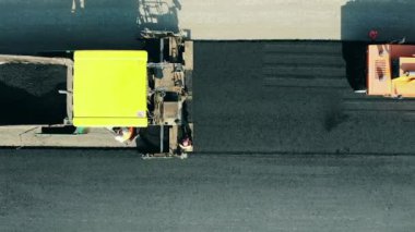 Yol silindirleri bitum yayıyor. Yol inşaatında asfalt kaldırım makinesi.