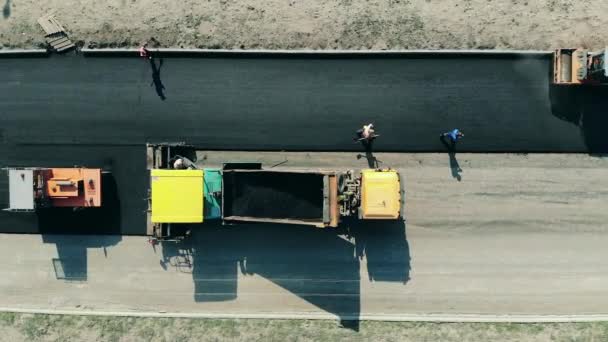 La chaussée est faite de bitum par les ouvriers. Machine de pavage d'asphalte sur un chantier de construction routière . — Video