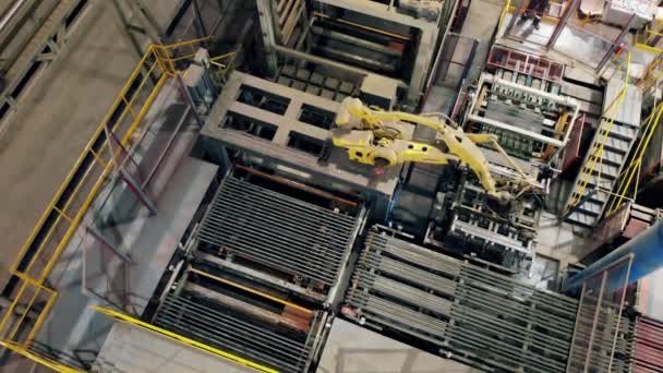 Robot kol, tuğlaları üst görüntüde hareket ettiriyor. Endüstriyel fabrikada çalışan otomatik robot kolu. — Stok video