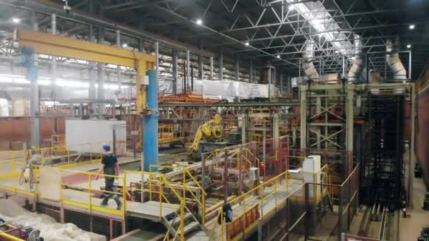 Les travailleurs marchent le long du hall industriel . — Video