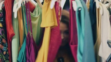 Bir giyim mağazasında genç ve mutlu bir bayanın fotoğrafını çek. Mağazada mutlu bayan alışverişleri.