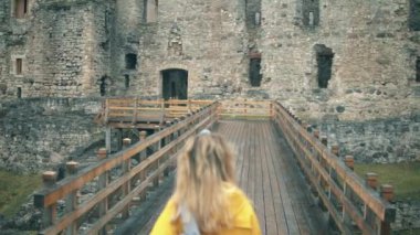 Elinde fener olan bir kadın tahta bir köprü boyunca yürüyor.