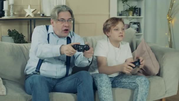 Ο ηλικιωμένος και ο εγγονός του κερδίζουν σε ένα βιντεοπαιχνίδι. — Αρχείο Βίντεο