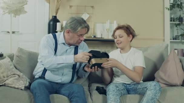 Senior homme met sur VR-lunettes avec ses petits-fils conseils — Video