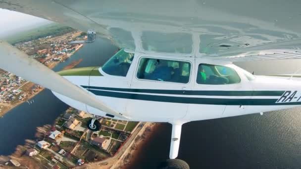 Вид збоку на невеликий літак, що летить над землею — стокове відео