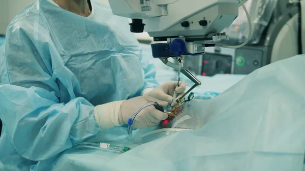 Oftalmolog ameliyat sırasında tıbbi alet kullanır..