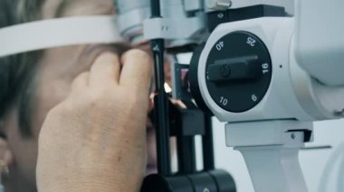 Oftalmolog hastaların görme duyusunu test etmek için makine kullanır..