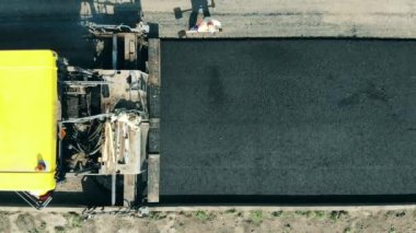 Paving makinesi yola asfalt seriyor.