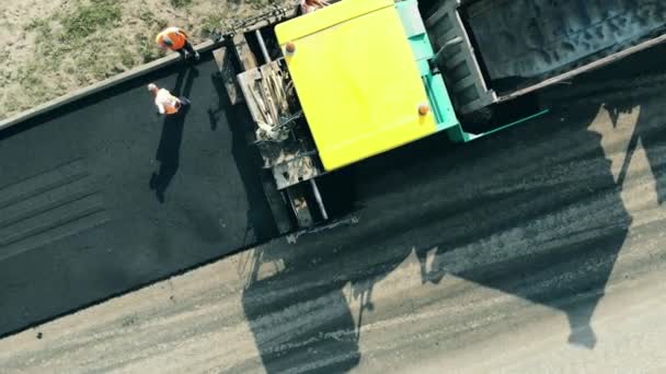 Strada asfaltata in corso con i lavoratori in vista dall'alto. Processo di costruzione di strade . — Video Stock