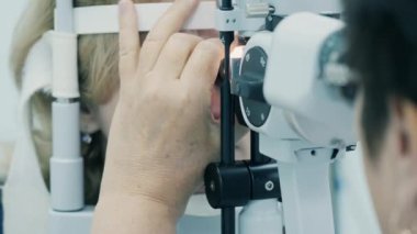 Bir doktor hasta görüşünü kontrol ediyor, makineyle..