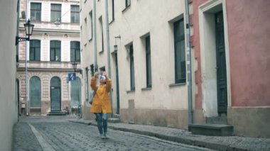 Turist eski kentteki binaların fotoğraflarını çekiyor.