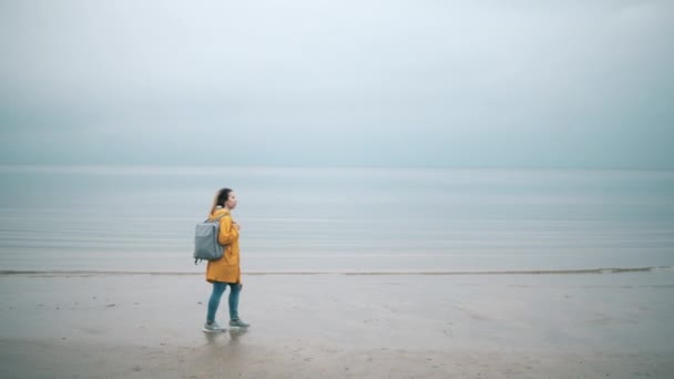 En turist går på en strand på hösten. Oväder. — Stockvideo