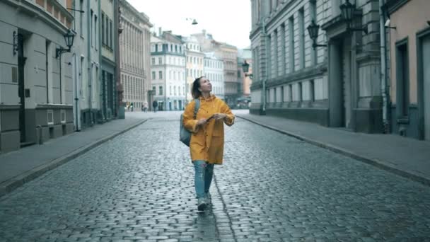 Turista feliz toma fotos mientras camina en un casco antiguo de la ciudad . — Vídeos de Stock
