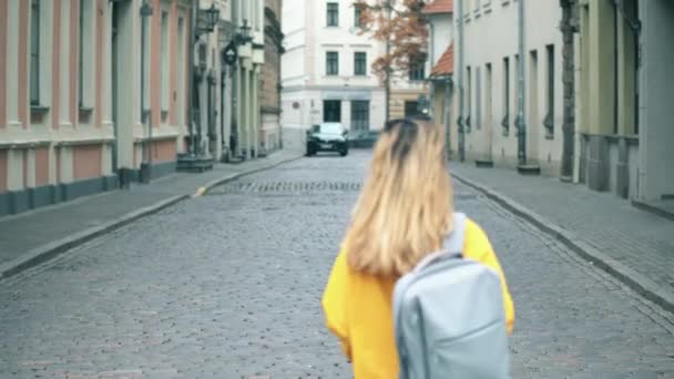 Şehrin tarihi bölgesinde bir kadın cadde boyunca yürüyor.. — Stok video