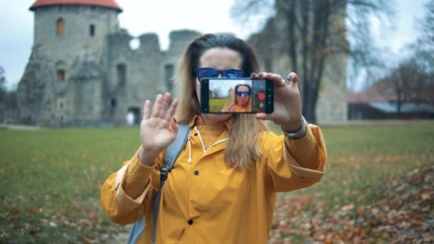 Jonge vrouw neemt een video over kasteel achtergrond. — Stockvideo
