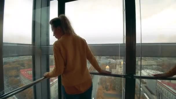 Женщина туристка в лифте, смотрит на город . — стоковое видео