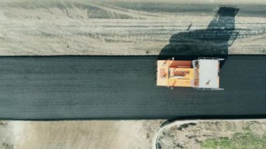 Yol İnşaat Alanı. Sıcak asfalt boyunca giden kaldırım makinesinin üst görüntüsü
