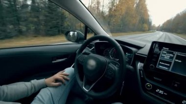 Otomatik pilota geçtiğinde adam arabada oturur. Otomatik pilot, akıllı araç, drivelless otomobil konsepti.