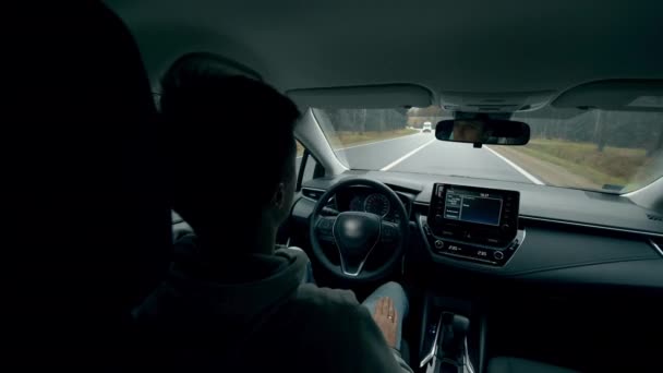 Der junge Mann sitzt im Auto auf Autopilot. Automatisches, selbstfahrendes Auto. — Stockvideo