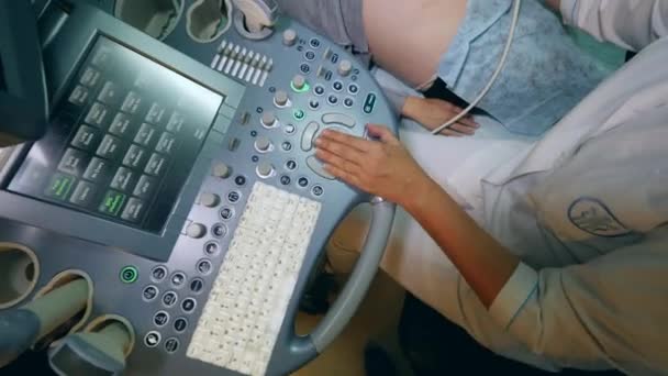 Female doctor checks pregnant patient with ultrasound machine. — Stock Video