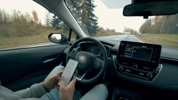 当汽车自动驾驶时，司机在电话上打字。 自动、自动驾驶汽车. — 图库视频影像