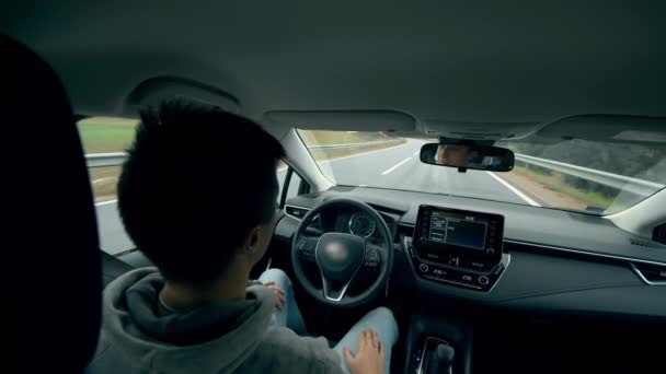 Automatische, zelfrijdende auto. Een persoon zit in een bestuurdersstoel terwijl een auto op automatische piloot gaat. — Stockvideo