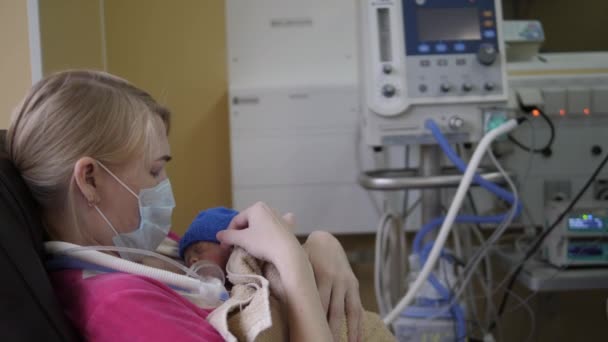 Kvinnan håller nyfödda barn i händerna på sjukhus. — Stockvideo