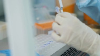 Laboratuvar çalışanı masadaki örnekleri test ediyor..