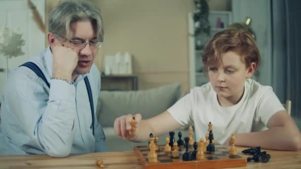 Дідусь пояснює шахи своєму онуку — стокове відео