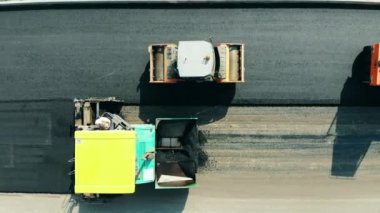 Yol yapım süreci. Bitum yayma makineleri otoyola tepeden bakıldığında