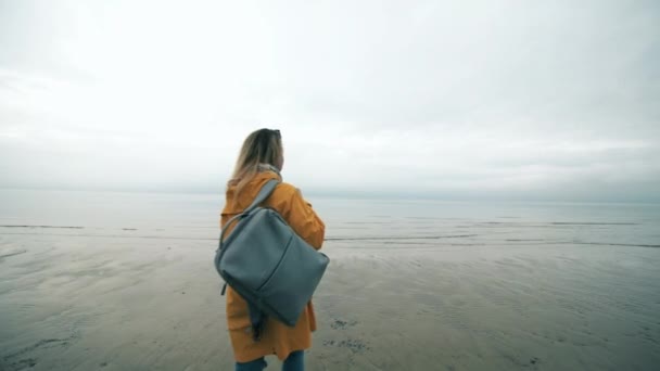 Meisje toeristische wandelingen op een kustlijn — Stockvideo