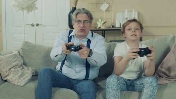 Een jongen wint bij de videogame voor zijn opa 's ogen. — Stockvideo