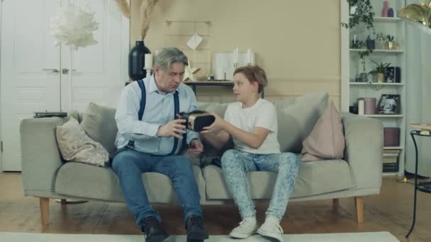 Un garçon apprend à son grand-père à utiliser des lunettes VR — Video