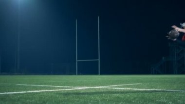 Bir adam topu tutarken düşer, yaklaş..