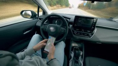 Otomatik pilotta araba kullanan bir adam cep telefonuyla çalışır..