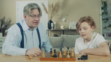 Büyükbaba genç torununa satrancı anlatıyor.