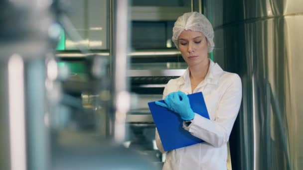 Trabalhadora da fábrica feminina está preenchendo uma placa de gráfico que trabalha na fábrica moderna . — Vídeo de Stock