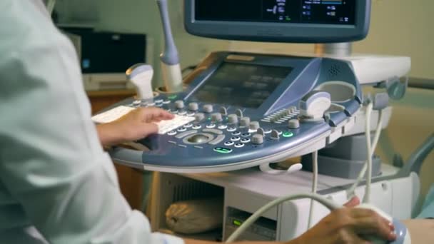 Доктор керує панеллю керування під час ультразвукового сканування — стокове відео