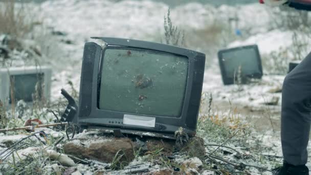 Una persona rompe la vieja televisión con un martillo en un vertedero. El hombre se estrella viejo televisor . — Vídeo de stock