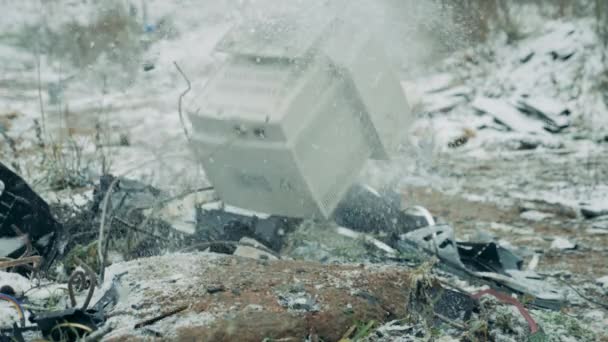 Uma velha TV sendo quebrada em uma lixeira no inverno . — Vídeo de Stock