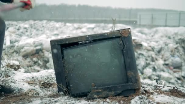 Чоловік знищує старий телевізор, використовуючи молоток. Чоловік з молотком стискає екран телевізора . — стокове відео