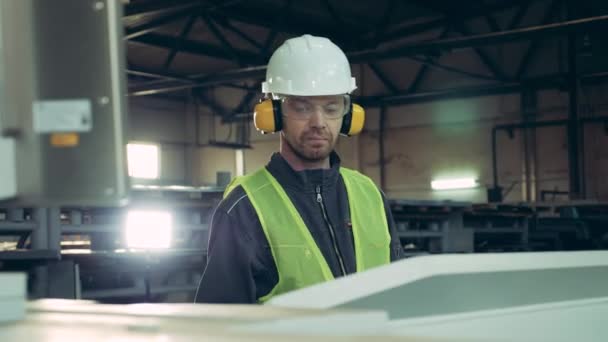 Работник мужского пола наблюдает за оборудованием завода во время работы с металлом — стоковое видео