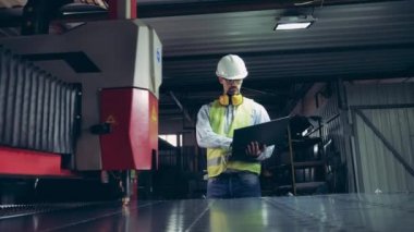 Fabrika çalışanı metal kesen lazer aletleri izliyor. Profesyonel Ağır Sanayi Mühendisi.