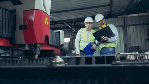 Fabriksarbetare undersöker en lasermaskin skära metall — Stockvideo