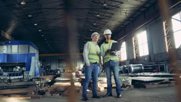 Ingénieurs professionnels de l'industrie lourde. Deux ouvriers parlent dans une usine de matériaux de construction — Video