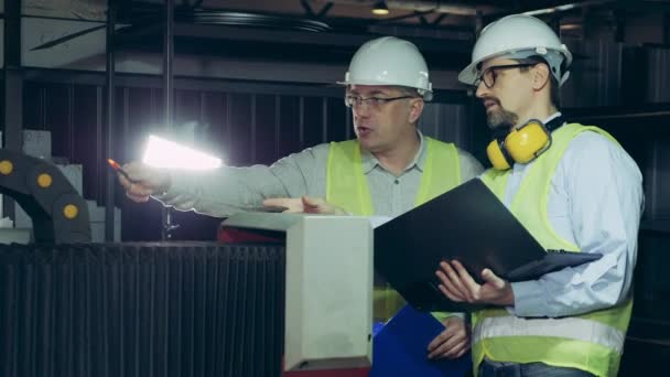 Los empleados masculinos están teniendo una discusión en una unidad de fábrica. Ingenieros masculinos en fábrica industrial . — Vídeos de Stock