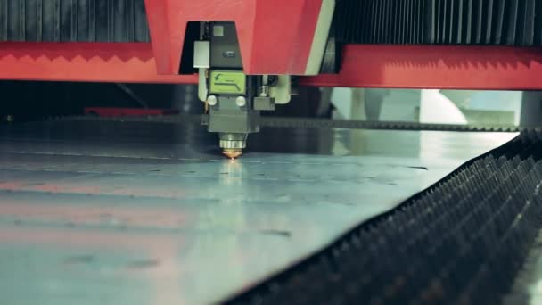 Close-up van een laser die kleine sneetjes maakt op een stuk metaal — Stockvideo