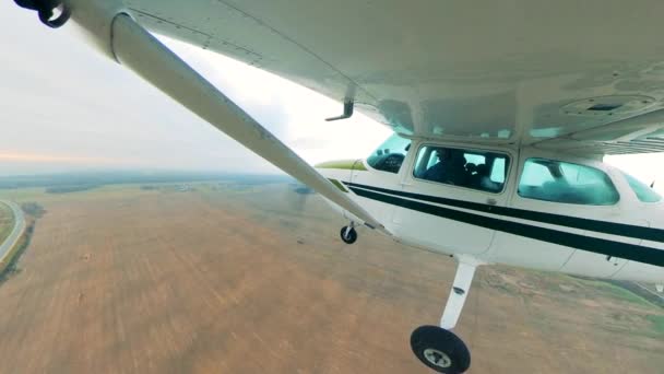 Pequeño avión vuela sobre un campo . — Vídeo de stock