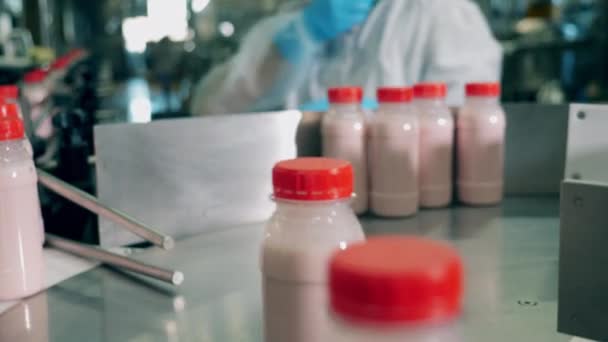 Пляшки з йогуртом рухаються на лінії на сирній фабриці. Харчова упаковка, конвеєр харчової фабрики, виробництво продуктів харчування . — стокове відео