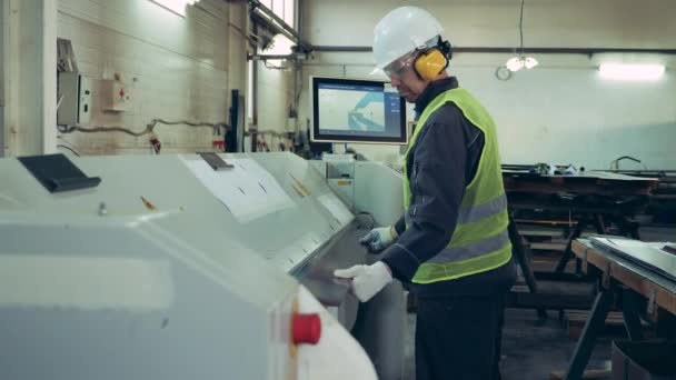 Trabalhador da fábrica está carregando uma folha de metal na máquina — Vídeo de Stock